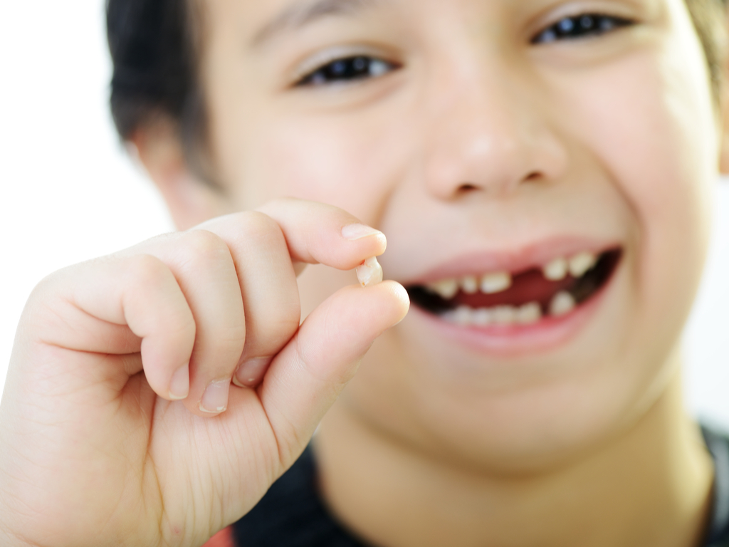 Child-holding-his-lost-tooth